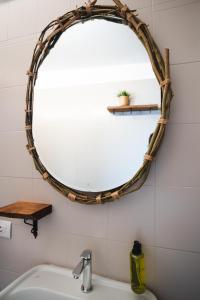 a bathroom with a large circular mirror on the wall at Briisa De Ness in Nesso