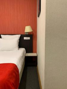 a hotel room with a bed and a lamp at East Gate Boutique Hotel in Tbilisi City