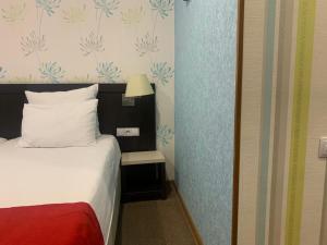 a bedroom with a bed and a lamp on a wall at East Gate Boutique Hotel in Tbilisi City +209 photos