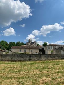 an old building with a castle in the background at Au Charme Charentais Gite geel in Blanzaguet-Saint-Cybard-le-Peyrat
