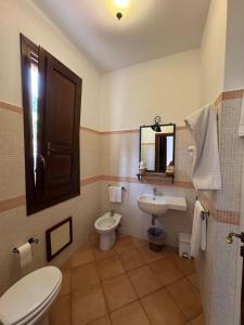 a bathroom with a toilet and a sink and a mirror at Kalura B&B in Macari