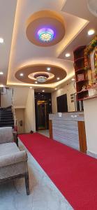 a lobby with a red carpet and a ceiling at Hotel Ramayanam palace in Ayodhya