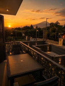 a balcony with a table and chairs and a sunset at Reale Mountain View in Mascalucia