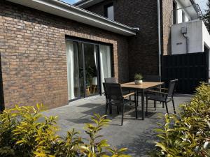 a patio with a table and chairs in front of a brick building at Gemütliche Wohnung mit Terrasse im Grünen in Bienenbüttel