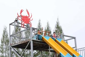 a group of people riding on a slide at a water park at มีดี ฟาร์ม โฮมสเตย์ in Ban Klam