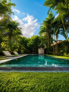 a swimming pool in a yard with palm trees at Baker's cottage in Kosgoda