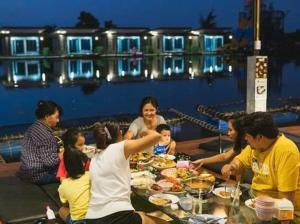 a group of people sitting around a table eating food at มีดี ฟาร์ม โฮมสเตย์ in Ban Klam