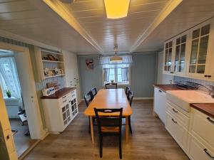 a kitchen with a wooden table and chairs in it at Fiskehuset Havnes in Averoy