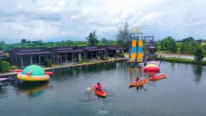 a group of people in boats in the water at a water park at มีดี ฟาร์ม โฮมสเตย์ in Ban Klam