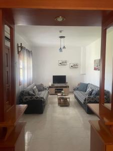a living room with two couches and a tv at Ariana's apartment in Orfánion