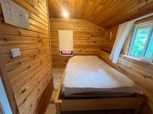 a bedroom in a wooden cabin with a bed in it at Naz Apartlari Cirali in Cıralı