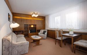 a living room with chairs and a table and a couch at Ferienhaus Freitag - Ferienwohnungen mit Sauna & Frühstück in Kurort Oberwiesenthal