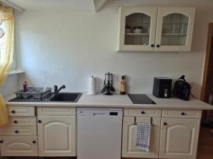 a kitchen with white cabinets and a sink at Familienwohnung Bella in Pirmasens