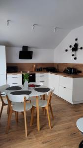a kitchen with a table and chairs in a room at Apartament DobraNocka in Ściegny