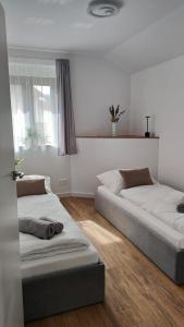 a bedroom with two beds and a window at Apartament DobraNocka in Ściegny
