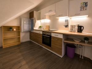 a kitchen with white cabinets and a wooden floor at Mitarbeiterwohnung nahe Saaleck Kaserne in Hammelburg