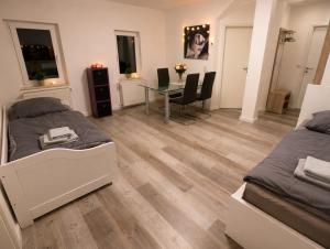a bedroom with two beds and a table with chairs at Mitarbeiterwohnung nahe Saaleck Kaserne in Hammelburg