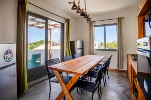 a kitchen and dining room with a wooden table and chairs at Le Morne Base - Stylish, Pool & Rooftop in La Gaulette +60 photos