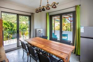 a dining room with a wooden table and chairs at Le Morne Base - Stylish, Pool & Rooftop in La Gaulette