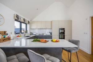 a kitchen with a large white counter with chairs at Jurassic in Dorchester +37 photos
