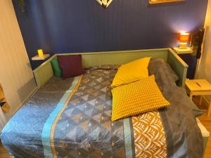 a bed with colorful pillows on it in a room at Appartement hyper centre in Caen
