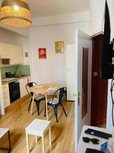 a room with a table and chairs and a kitchen at Appartement hyper centre in Caen +5 photos