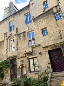 an old stone building with windows and a clock tower at Appartement hyper centre in Caen