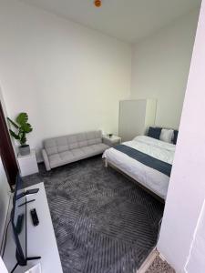 a bedroom with a bed and a couch at روز للاستديوهات المفروشة in Abu Dhabi