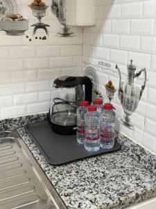 a toaster and bottles of water on a tray on a kitchen counter at روز للاستديوهات المفروشة in Abu Dhabi
