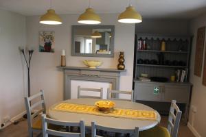 a dining room with a table and a fireplace at Ty Clyd in Pembrokeshire
