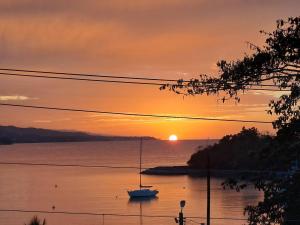 a boat on the water with a sunset in the background at By The Bay 2plus2 in Oracabessa