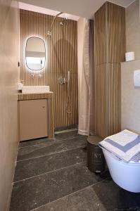 a bathroom with a toilet and a sink and a mirror at Iraklia Coral in Nea Irakleia +42 photos