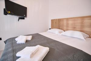 a bedroom with a large bed with two towels on it at Iraklia Coral in Nea Irakleia