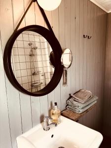 a bathroom with a sink and a mirror at Mysig stuga i Haverdal nära strand, hav och naturreservat in Haverdal +10 photos
