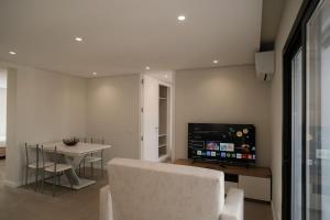 a living room with a couch and a table and a tv at Alba Esposende - Balcony Apartment in Esposende