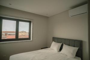 a bedroom with a bed and a window at Alba Esposende - Balcony Apartment in Esposende