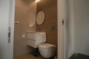 a bathroom with a white toilet and a mirror at Alba Esposende - Balcony Apartment in Esposende +39 photos