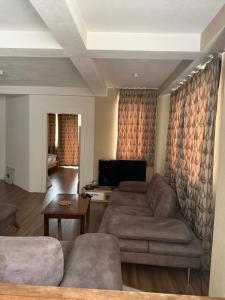 a living room with a couch and a table at Vila Tigani in Peje