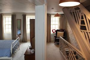 a bedroom with a staircase leading to a bedroom with a bed at Ty Clyd in Pembrokeshire