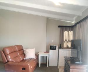 a living room with a couch and a kitchen at the Moonflower in Mbabane