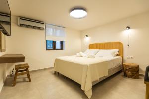 a bedroom with a large bed with white sheets at Villa Metochi in Skala +17 photos