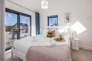 a bedroom with a white bed with a large window at Dawn Lighthouse in Dorchester