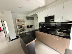 a kitchen with white cabinets and a sink at Vila Tigani in Peje