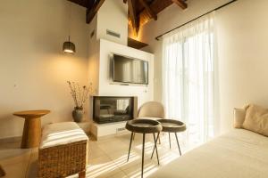 a living room with a bed and a television and stool at Villa Metochi in Skala