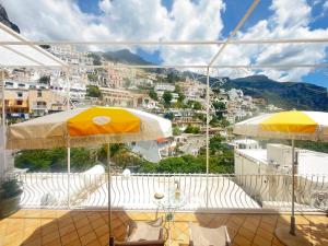 a balcony with umbrellas and a view of a city at Domus Floris in Positano +11 photos