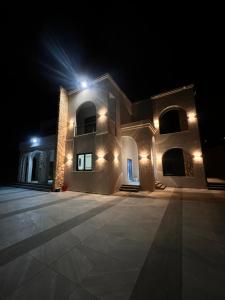 a large building with lights on it at night at ڤيلا الكرم in Jerash