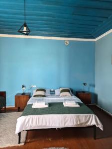 a blue walled bedroom with a bed in a room at Noosh Ashnak guesthouse in Ashnak