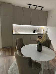 a kitchen with a white table and chairs at Golden Nest in Tuzla
