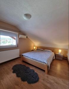 a bedroom with a large bed and a window at Apartman Avram in Kotor-Varoš
