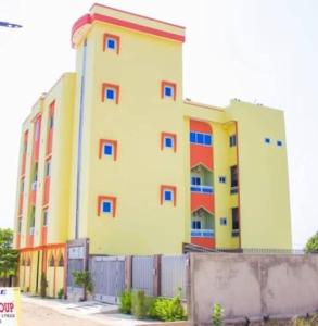 a large yellow building with colorful windows at Résidence Hôtel KOUNAF GROUP in Parakou
